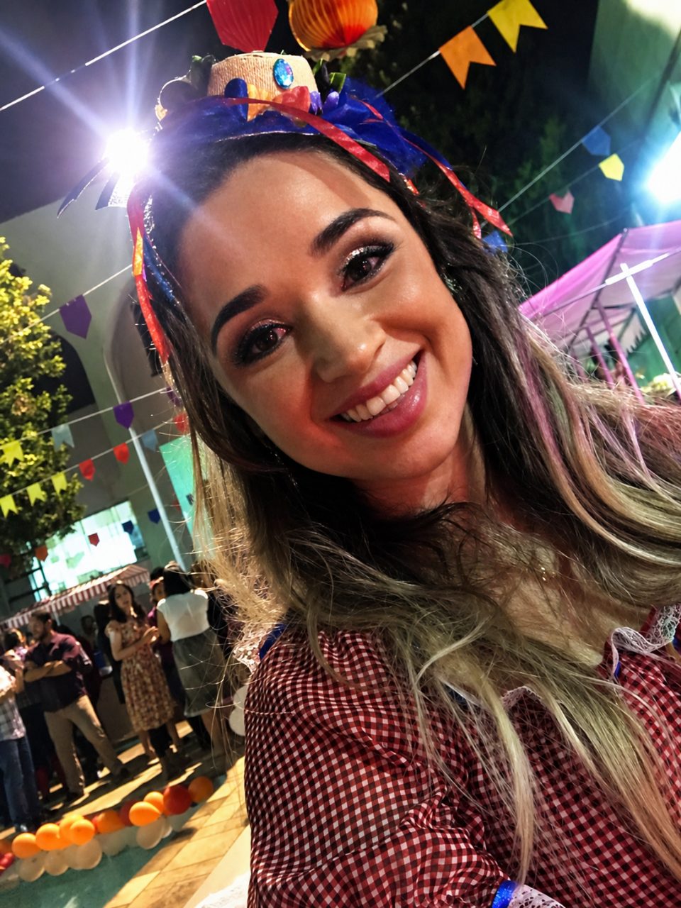 Luiza sorrindo, radiante, numa festa junina
